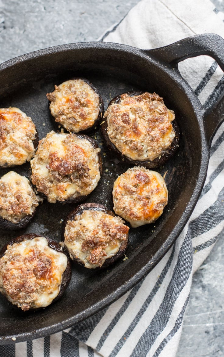 sausage and cream cheese stuffed mushrooms in a cast iron pan 