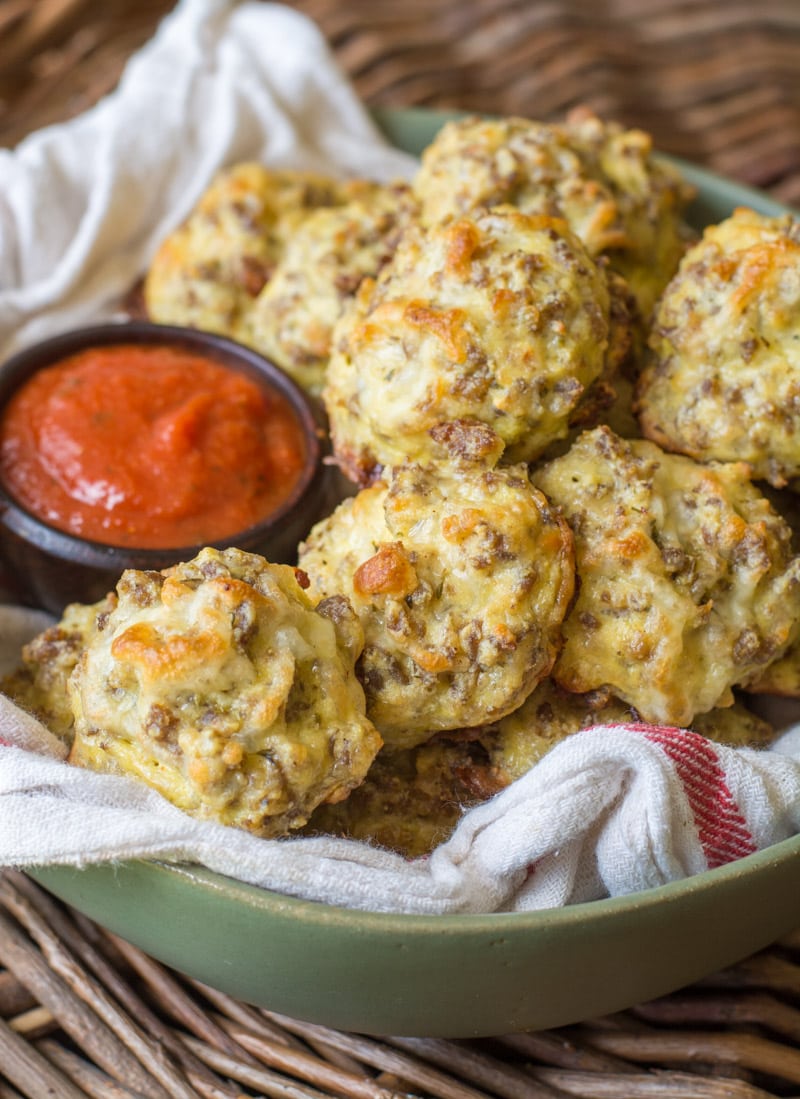 keto pizza bites in a green bowl with a side of marinara sauce 