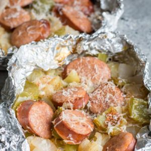 Keto Sausage and Cabbage Foil Packs are loaded with spicy sausage, bell pepper, onion, and cabbage in a cajun butter sauce! A perfect low carb meal for camping or grilling out! #keto