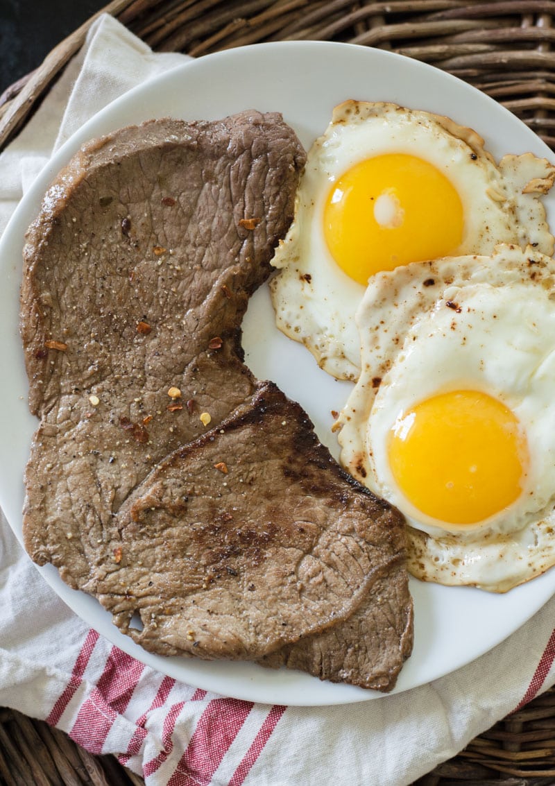 breakfast steak and eggs on a white plate 