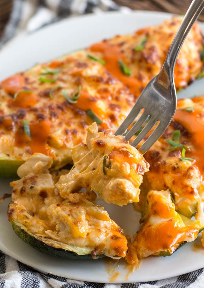 Try these Keto Buffalo Chicken Zucchini Boats packed with tangy buffalo sauce, chicken and cheese! These zucchini boats are cooked in either an air fryer or oven for a delicious low carb meal! #keto