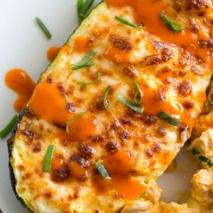 Try these Keto Buffalo Chicken Zucchini Boats packed with tangy buffalo sauce, chicken and cheese! These zucchini boats are cooked in either an air fryer or oven for a delicious low carb meal! #keto