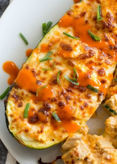 Try these Keto Buffalo Chicken Zucchini Boats packed with tangy buffalo sauce, chicken and cheese! These zucchini boats are cooked in either an air fryer or oven for a delicious low carb meal! #keto