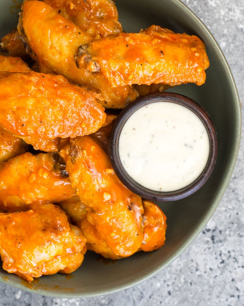 overhead view of air fryer wings on a plate with ranch sauce 