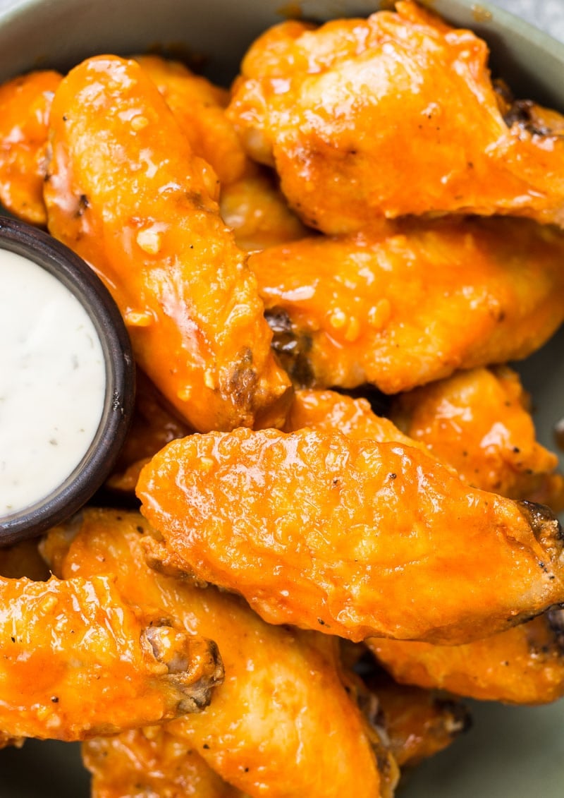 air fryer buffalo wings with a dish of ranch 