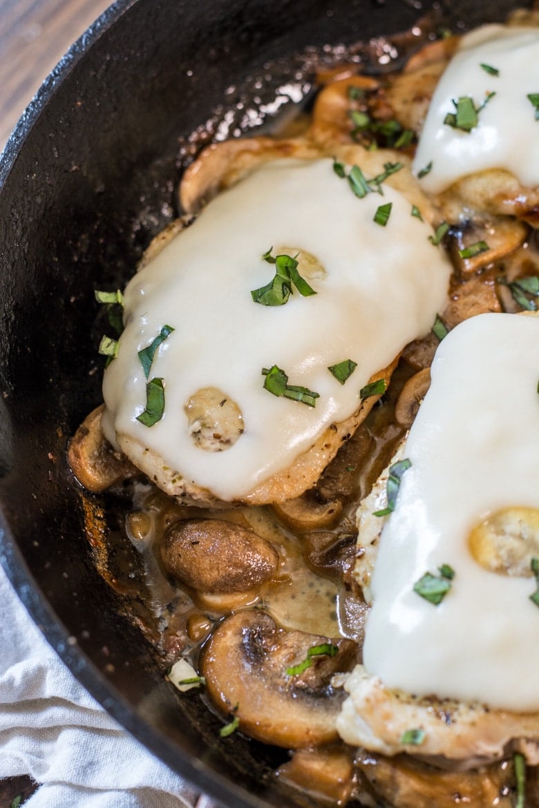 Close up overhead view of mushroom swiss chicken in a skillet. 