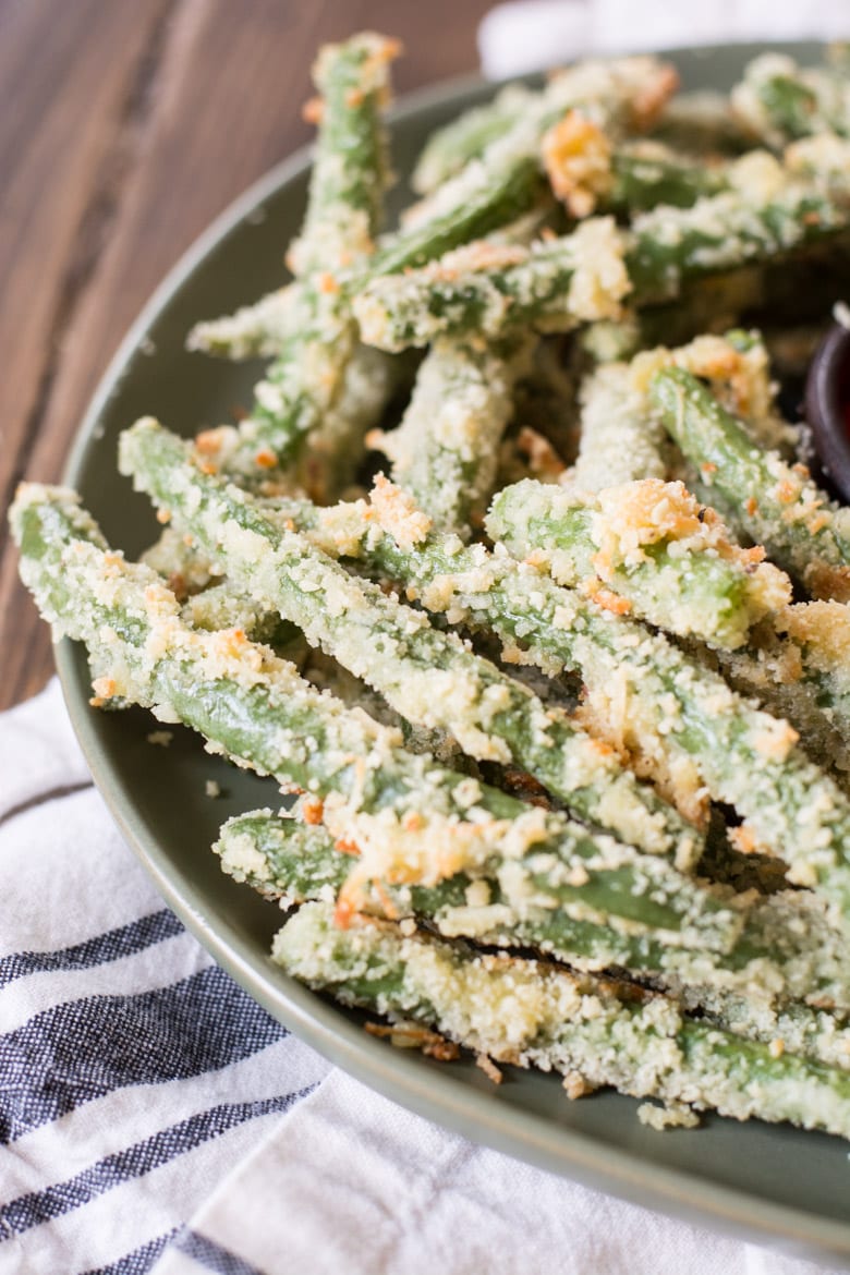close up view of green bean fries on a large green plate