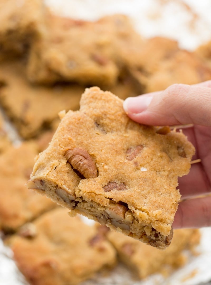 An almond flour blondie being held aloft. 