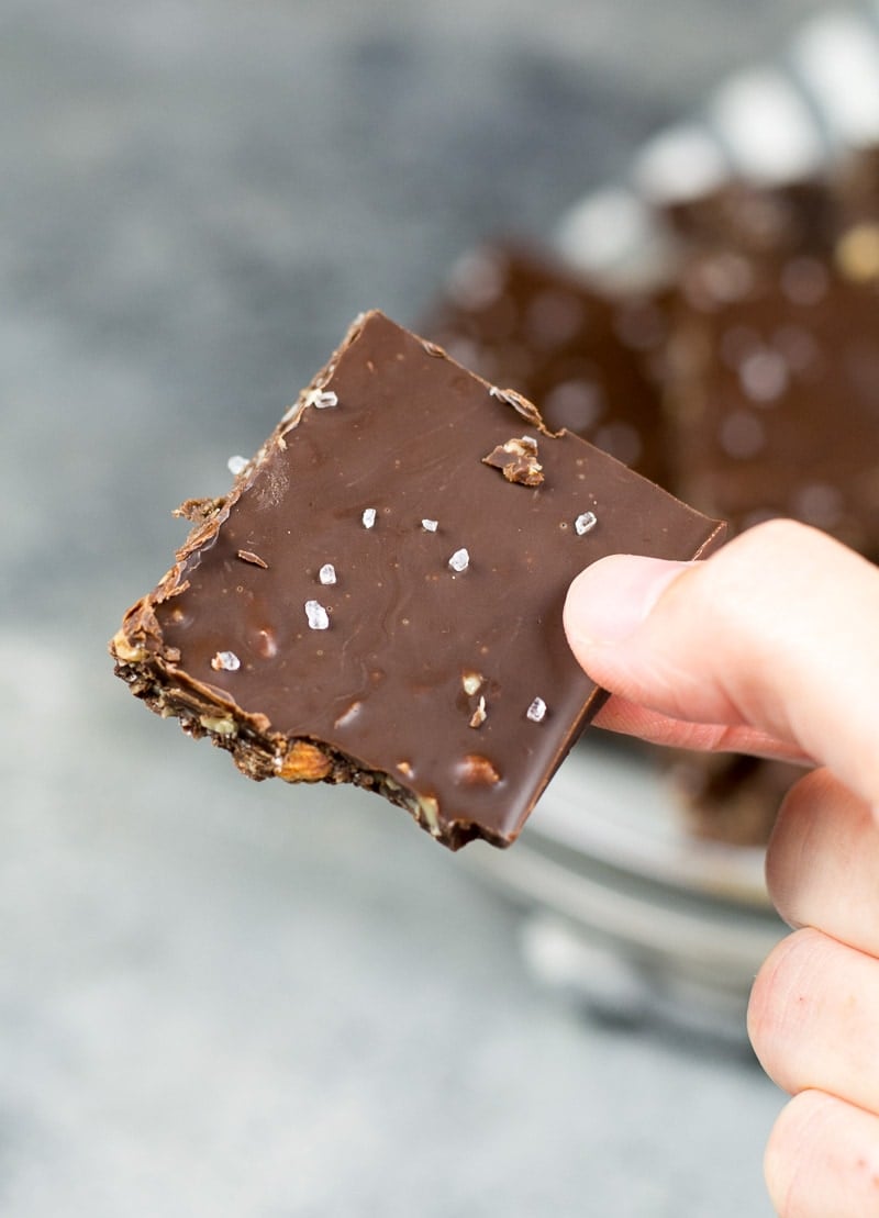 a piece of keto peppermint bark being held aloft 