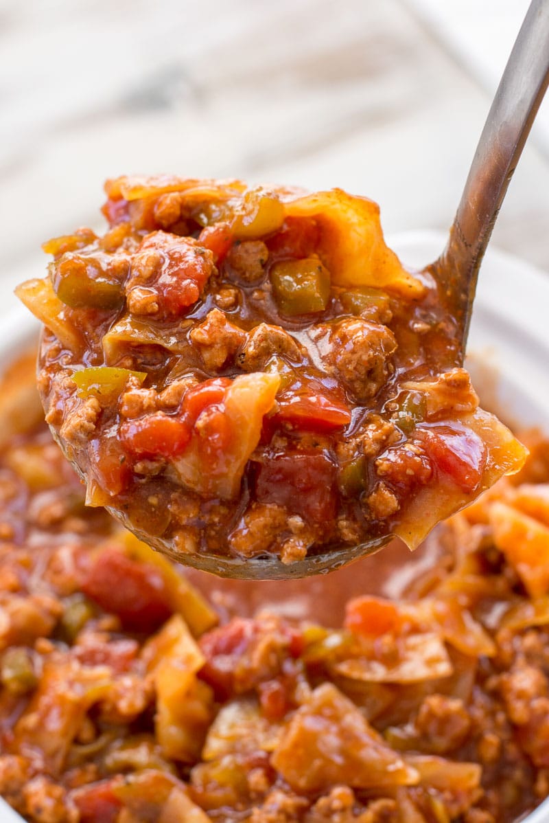 close up of a ladle full of unstuffed cabbage roll soup