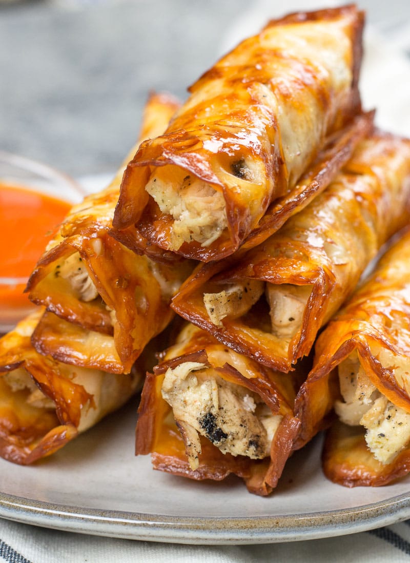 A stack of buffalo chicken taquitos on a white plate. 