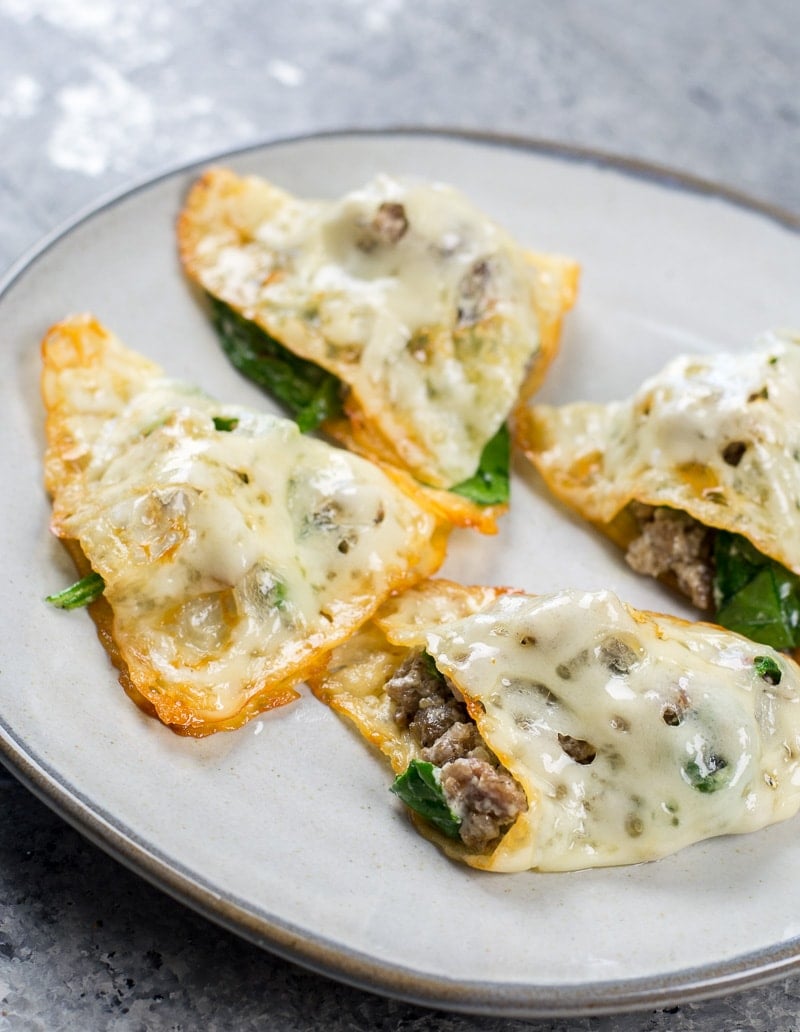 Four low carb ravioli on a white plate, plain. 