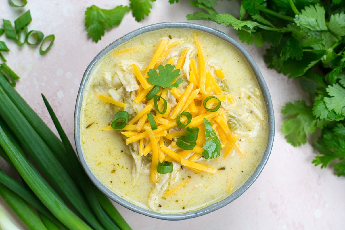 This Keto White Chicken Chili is loaded with shredded chicken, chilis, peppers and cauliflower rice! At about 7.5 net carbs per heaping serving this is the ultimate creamy keto comfort food!