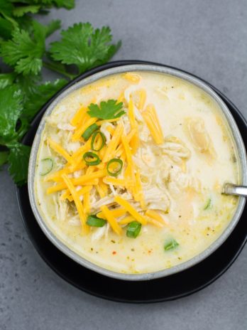 This Keto White Chicken Chili is loaded with shredded chicken, chilis, peppers and cauliflower rice! At about 7.5 net carbs per heaping serving this is the ultimate creamy keto comfort food!