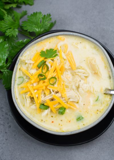 This Keto White Chicken Chili is loaded with shredded chicken, chilis, peppers and cauliflower rice! At about 7.5 net carbs per heaping serving this is the ultimate creamy keto comfort food!