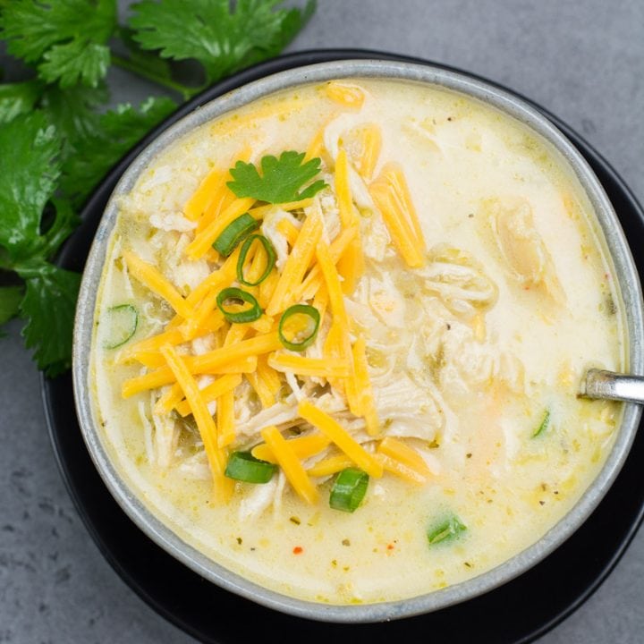 This Keto White Chicken Chili is loaded with shredded chicken, chilis, peppers and cauliflower rice! At about 7.5 net carbs per heaping serving this is the ultimate creamy keto comfort food!