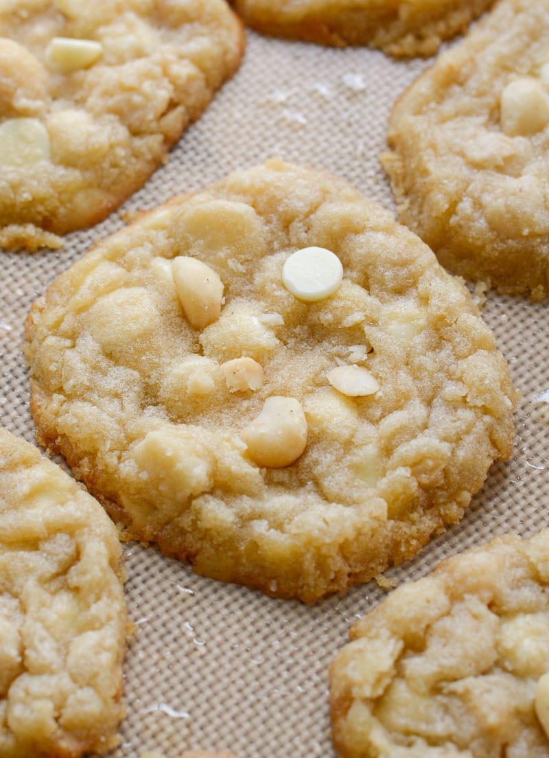 close up of keto white chocolate chip macadamia nut cookies on a baking sheet 