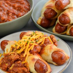 These Keto Chili Cheese Dogs have everything you love about this classic, without the carbs! Easy, low carb, gluten free pigs in a blanket are smothered with keto chili and shredded cheddar cheese! For about 5 net carbs per serving this is a low carb recipe you will love! 