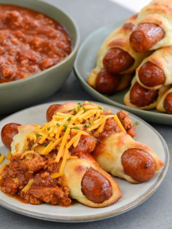 These Keto Chili Cheese Dogs have everything you love about this classic, without the carbs! Easy, low carb, gluten free pigs in a blanket are smothered with keto chili and shredded cheddar cheese! For about 5 net carbs per serving this is a low carb recipe you will love! 