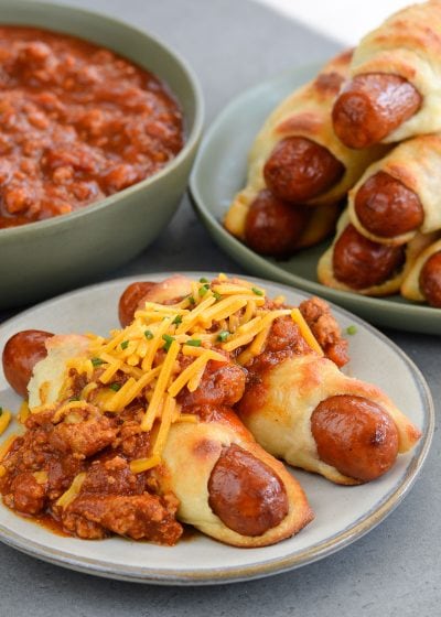 These Keto Chili Cheese Dogs have everything you love about this classic, without the carbs! Easy, low carb, gluten free pigs in a blanket are smothered with keto chili and shredded cheddar cheese! For about 5 net carbs per serving this is a low carb recipe you will love! 