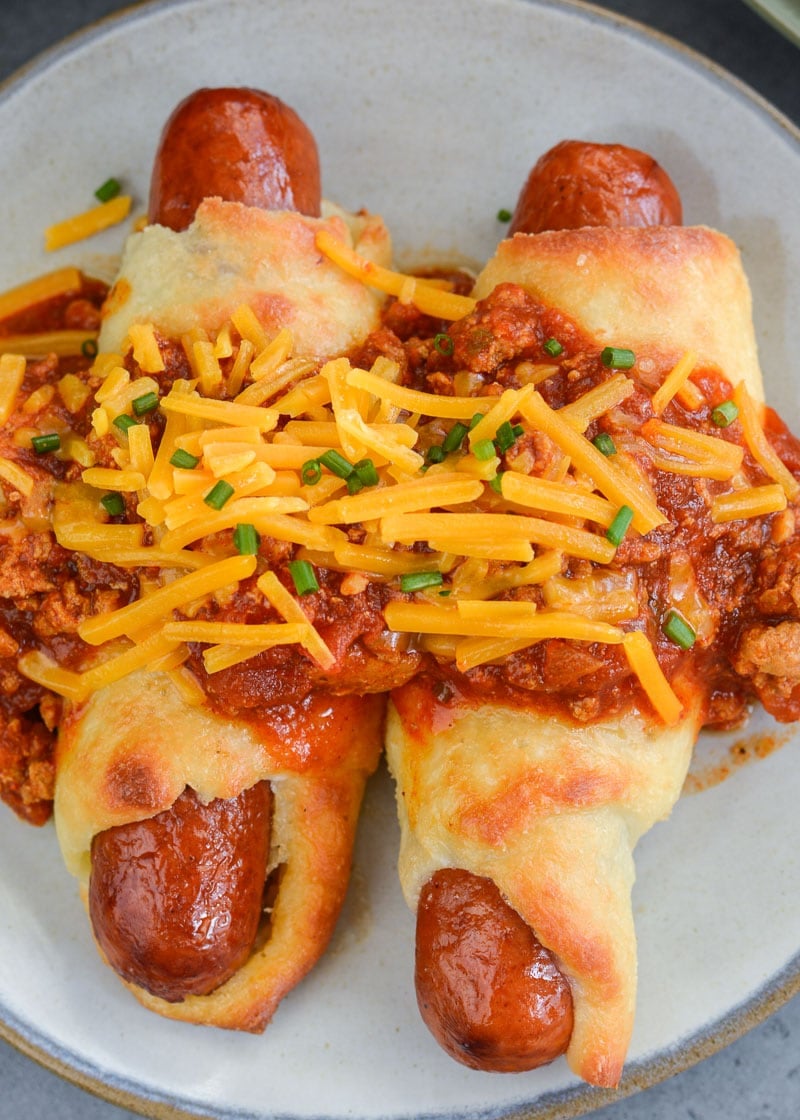 These Keto Chili Cheese Dogs have everything you love about this classic, without the carbs! Easy, low carb, gluten free pigs in a blanket are smothered with keto chili and shredded cheddar cheese! For about 5 net carbs per serving this is a low carb recipe you will love! 