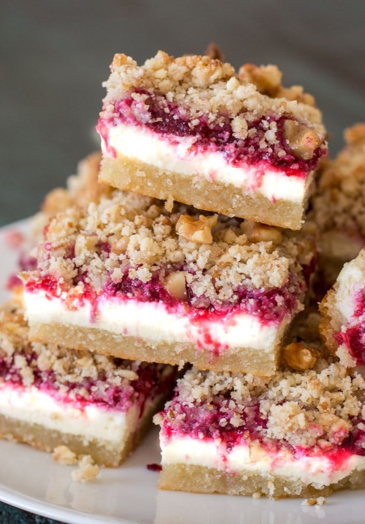stacked keto cranberry cheesecake bars on a white plate