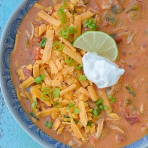 This Keto Cheesy Chicken Enchilada Soup has just about 6 net carbs and is super creamy! Top with shredded cheese, sour cream, green onions, and a squeeze of lime to bring it over the top!