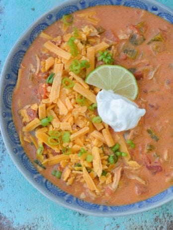 This Keto Cheesy Chicken Enchilada Soup has just about 6 net carbs and is super creamy! Top with shredded cheese, sour cream, green onions, and a squeeze of lime to bring it over the top!