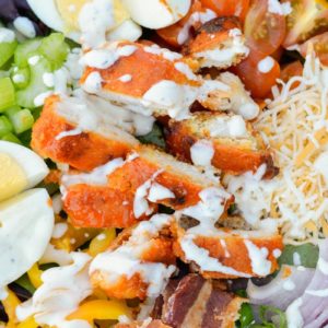 This Buffalo Chicken Cobb Salad is loaded with spicy chicken, crispy bacon, sharp cheddar cheese and loads of vegetables! Each generous serving has about 7 net carbs making it a great low carb dinner option! 