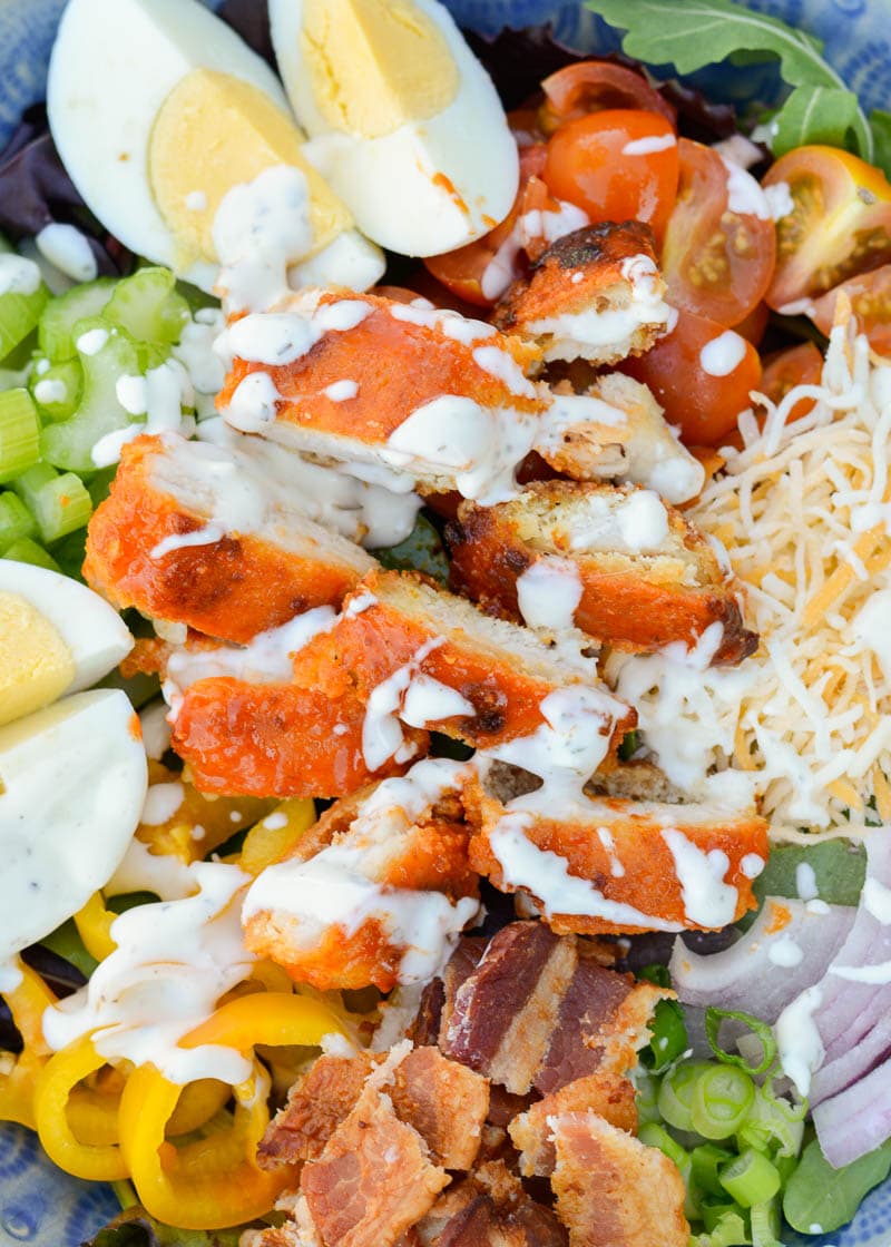 This Buffalo Chicken Cobb Salad is loaded with spicy chicken, crispy bacon, sharp cheddar cheese and loads of vegetables! Each generous serving has about 7 net carbs making it a great low carb dinner option!