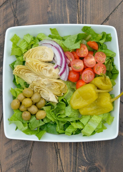 This Keto Antipasto Salad is full of flavor with green olives, pepperoncini peppers, artichokes, red onion, and tomatoes.