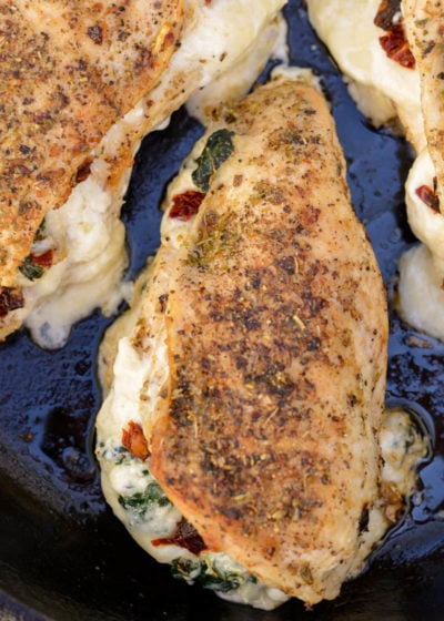 This easy Spinach Stuffed Chicken recipe is stuffed with cheese, tender spinach and delicious sun dried tomatoes! This one pan recipe is naturally low carb and comes together in 30 minutes!