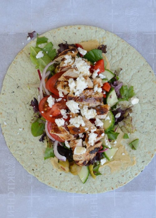 This easy Greek Chicken Wrap is the perfect healthy lunch idea! A soft wrap is loaded with grilled chicken, vegetables, hummus, feta and olives!