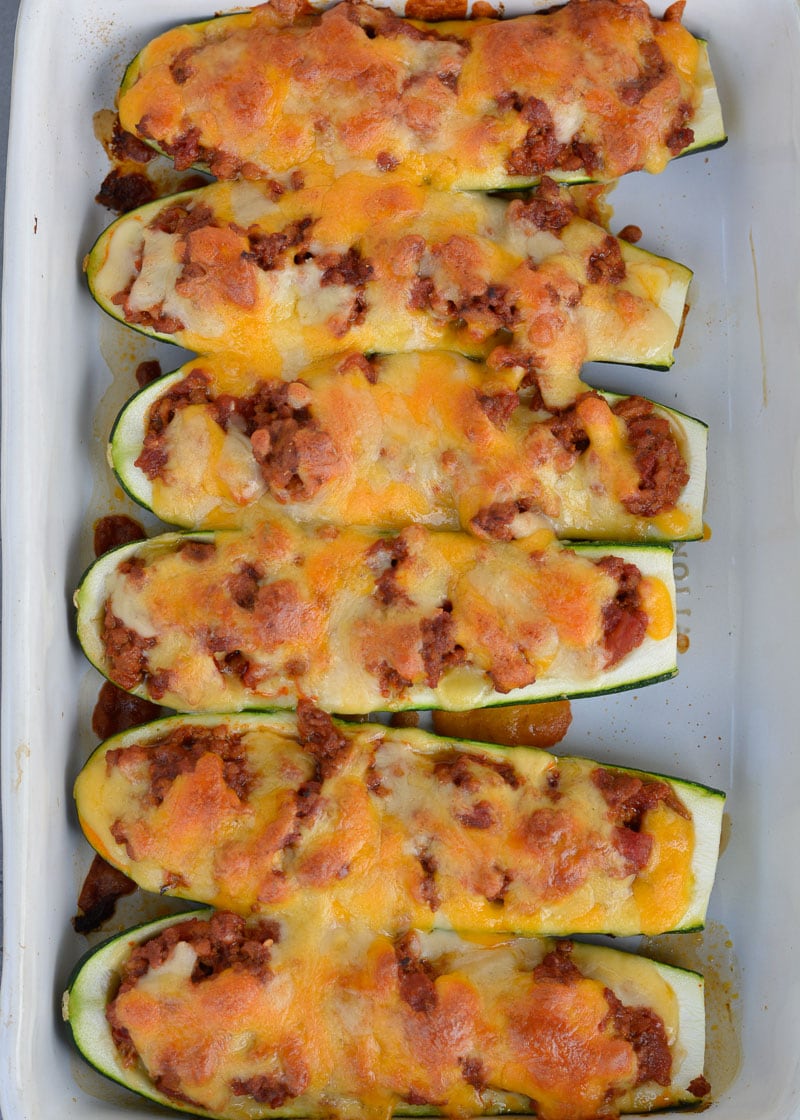 Warning! These Chili Cheese Stuffed Zucchini Boats are super addictive! Fresh zucchini is stuffed with keto chili and topped with sharp cheddar cheese!