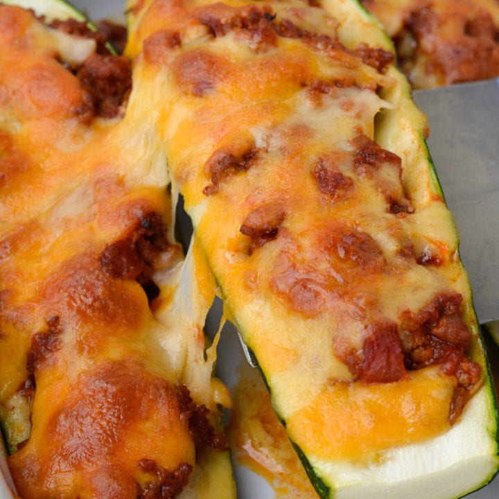 Warning! These Chili Cheese Stuffed Zucchini Boats are super addictive! Fresh zucchini is stuffed with keto chili and topped with sharp cheddar cheese!