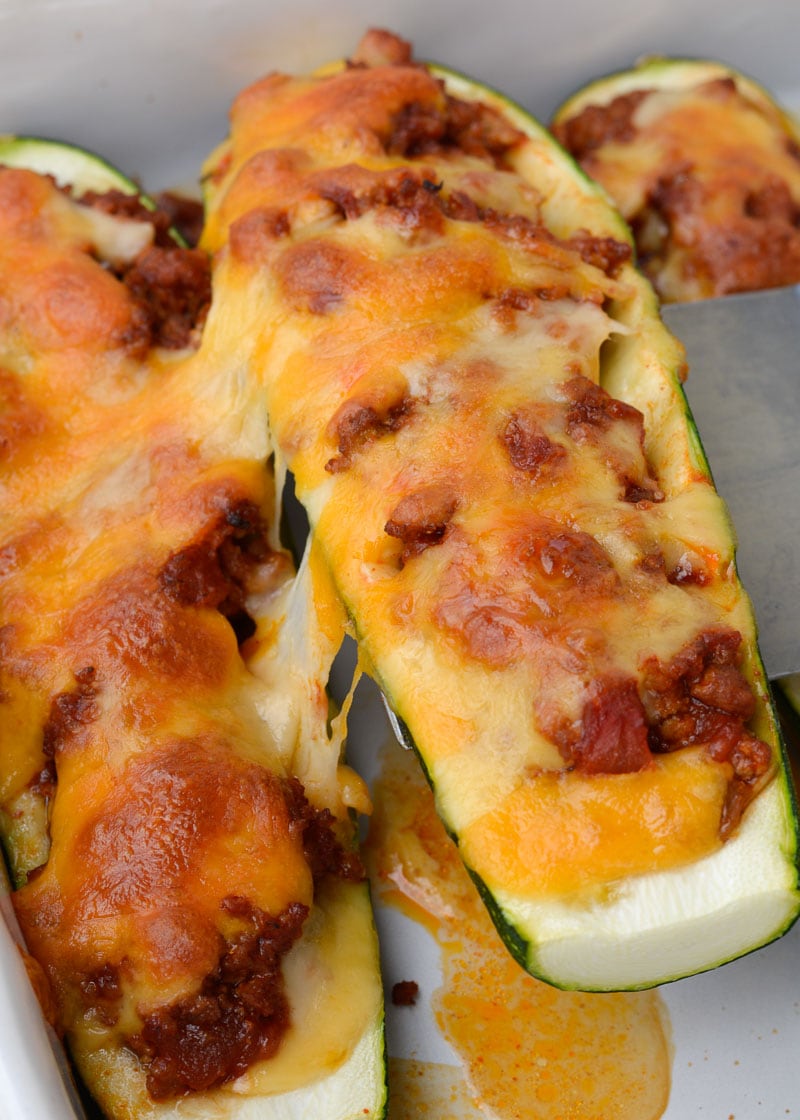 Warning! These Chili Cheese Stuffed Zucchini Boats are super addictive! Fresh zucchini is stuffed with keto chili and topped with sharp cheddar cheese!