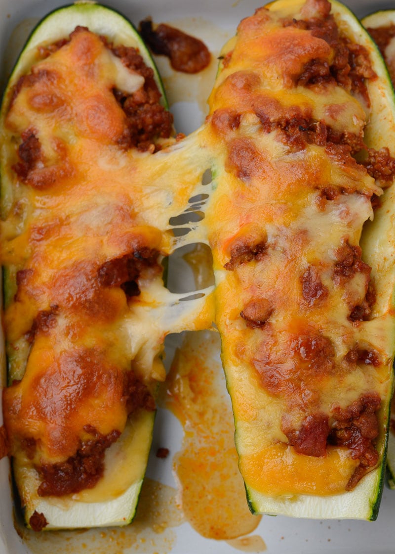 Warning! These Chili Cheese Stuffed Zucchini Boats are super addictive! Fresh zucchini is stuffed with keto chili and topped with sharp cheddar cheese!