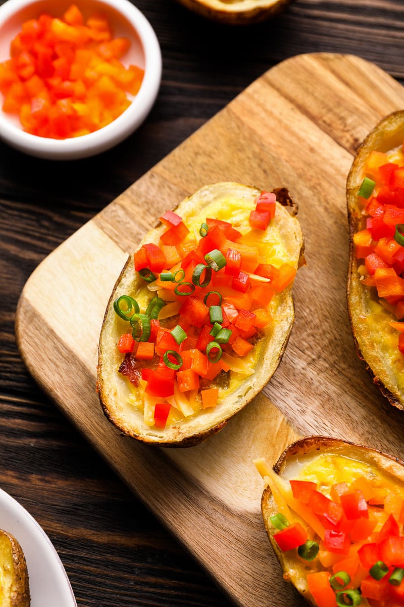 Start your day with these protein packed Breakfast Potatoes! Bacon, egg and cheddar cheese are packed in a crispy potato skin and seasoned with spicy green chilies! This easy breakfast recipe is perfect for meal prep, brunch or a family get together!