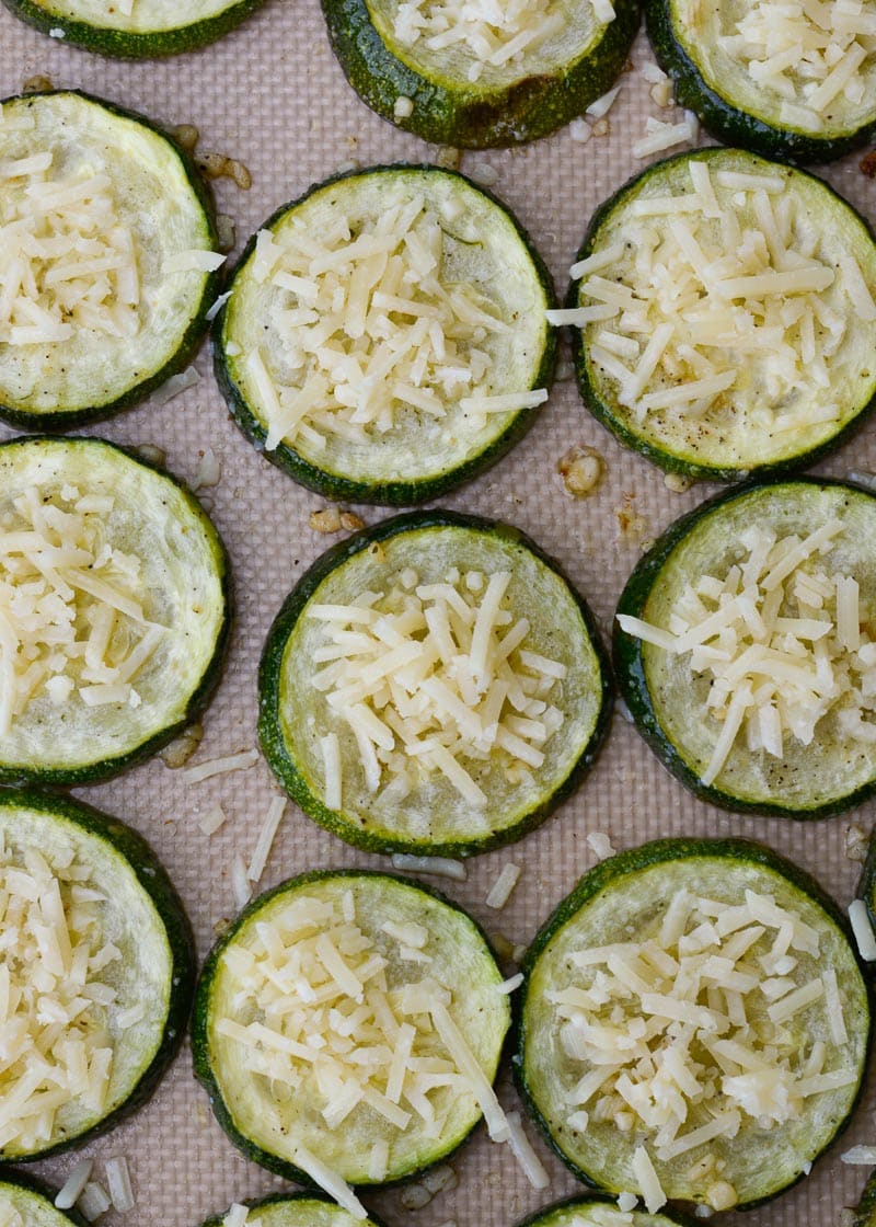 Overhead view of roasted zucchini with parmesan on silpat, after adding cheese