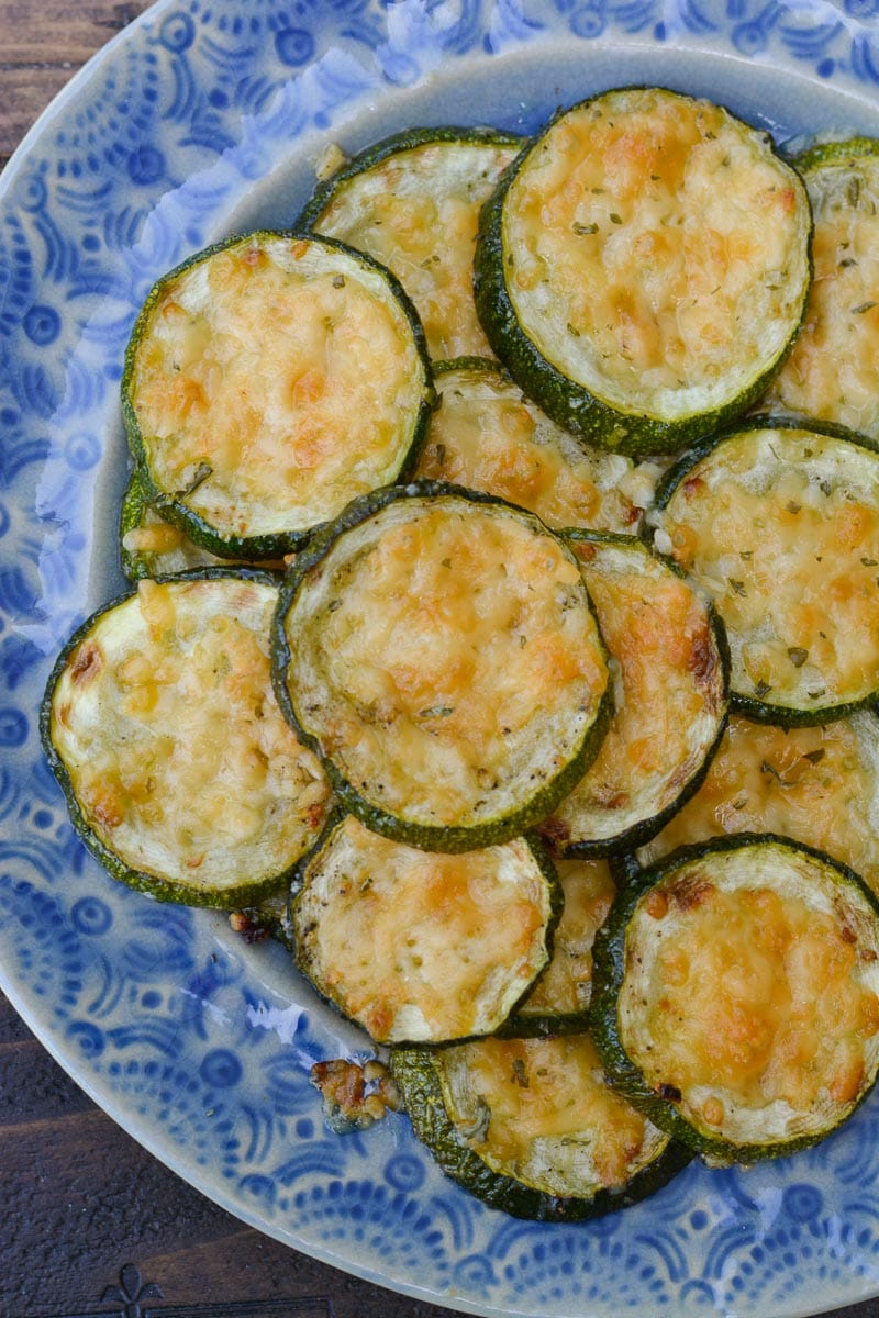 Overhead view of roasted zucchini with parmesan on plate with blue and white pattern