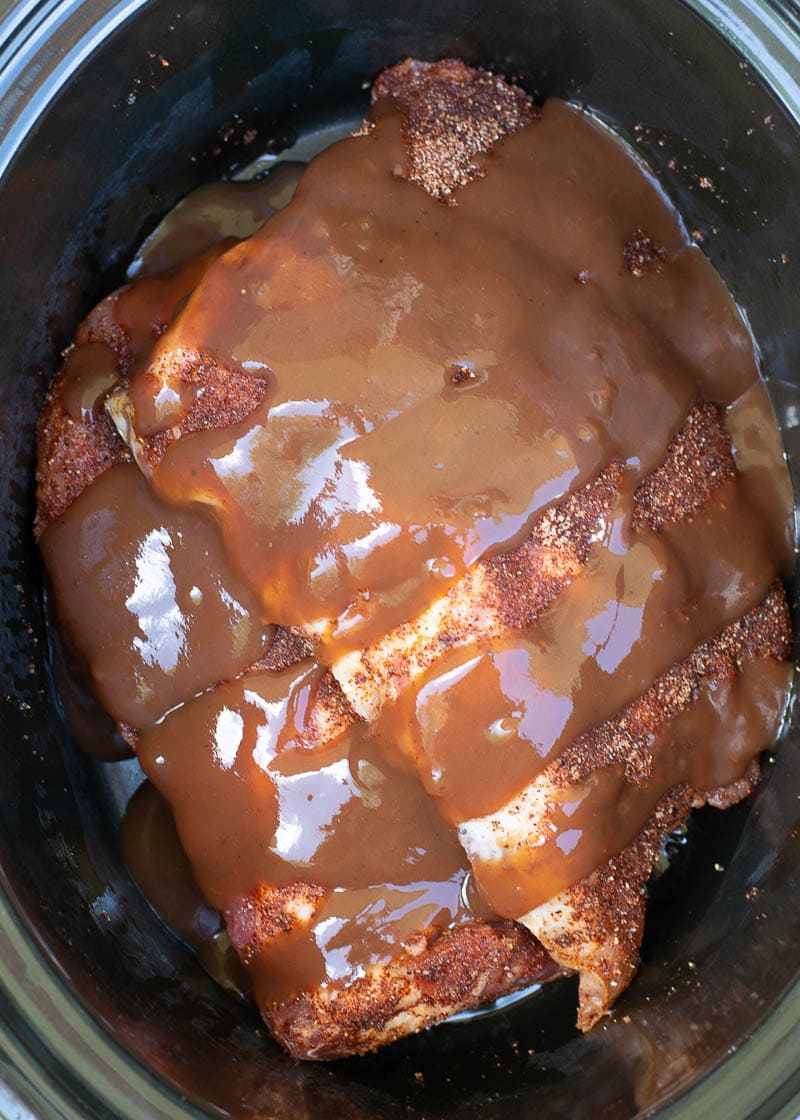 Try these ultra tender Crock Pot Ribs for the perfect easy meal! First ribs are seasoned with a smokey BBQ rub, cooked until super tender and then smothered in BBQ sauce and broiled to perfection! 