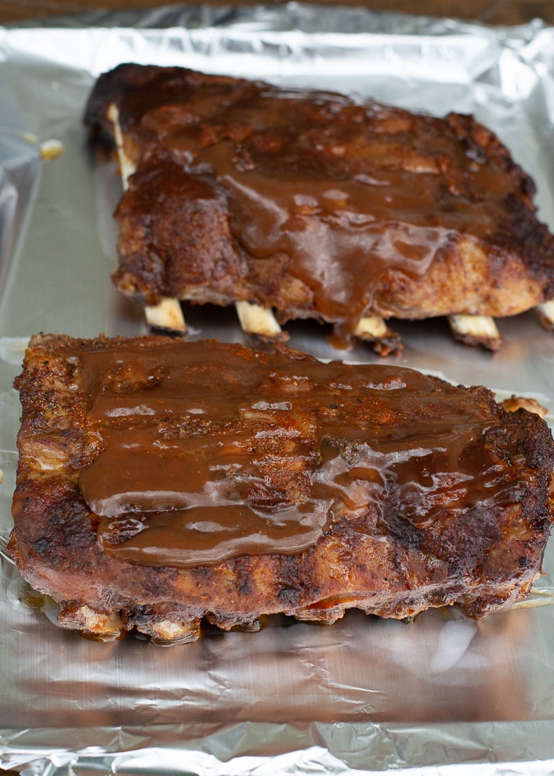Try these ultra tender Crock Pot Ribs for the perfect easy meal! First ribs are seasoned with a smokey BBQ rub, cooked until super tender and then smothered in BBQ sauce and broiled to perfection! 