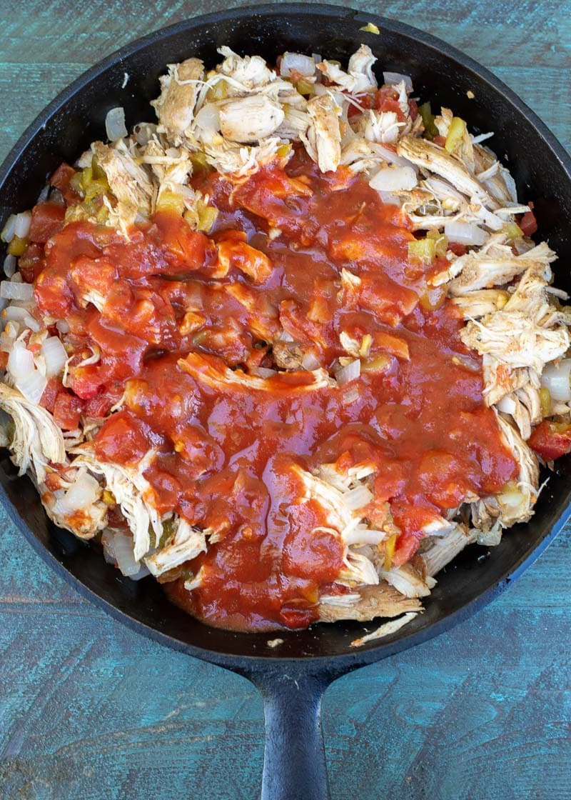 an over head shot of the filling for chicken enchiladas in a skillet