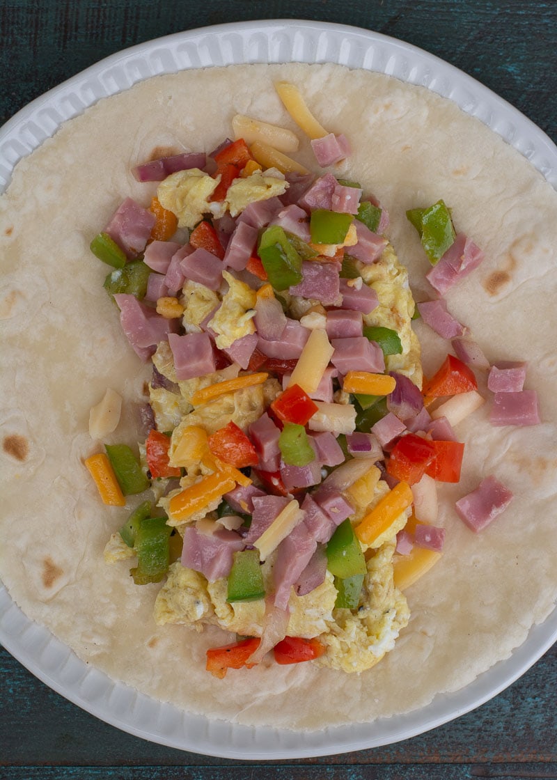 This Denver Omelette Breakfast Burrito is a delicious low carb breakfast! Fluffy eggs are combined with peppers, onions, ham and cheese, making a perfect meal prep recipe!