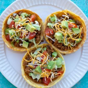 This Taco Chaffle Bowl is the perfect keto version of your favorite taco salad! Seasoned taco meat, cheese, lettuce and sour cream are combined in a crispy Chaffle Bowl for less than 3 net carbs!