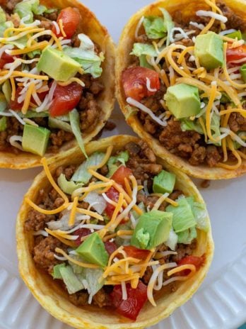 This Taco Chaffle Bowl is the perfect keto version of your favorite taco salad! Seasoned taco meat, cheese, lettuce and sour cream are combined in a crispy Chaffle Bowl for less than 3 net carbs!