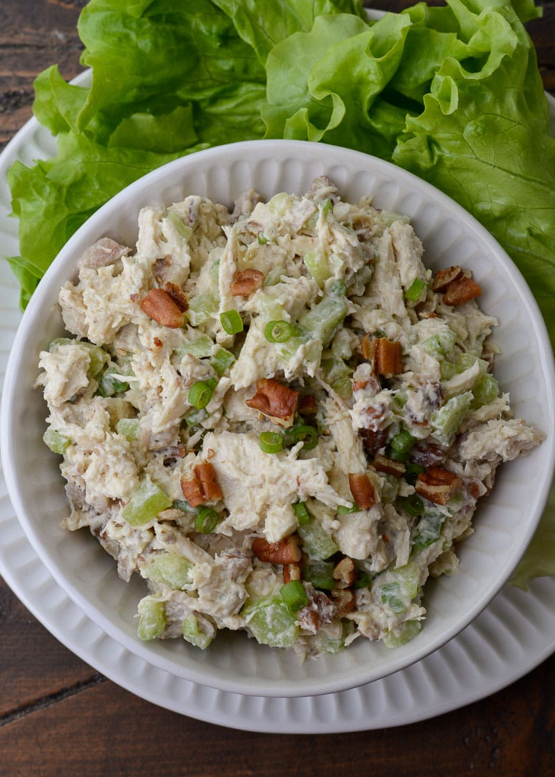chicken salad garnished with green onions and walnuts in a white bowl