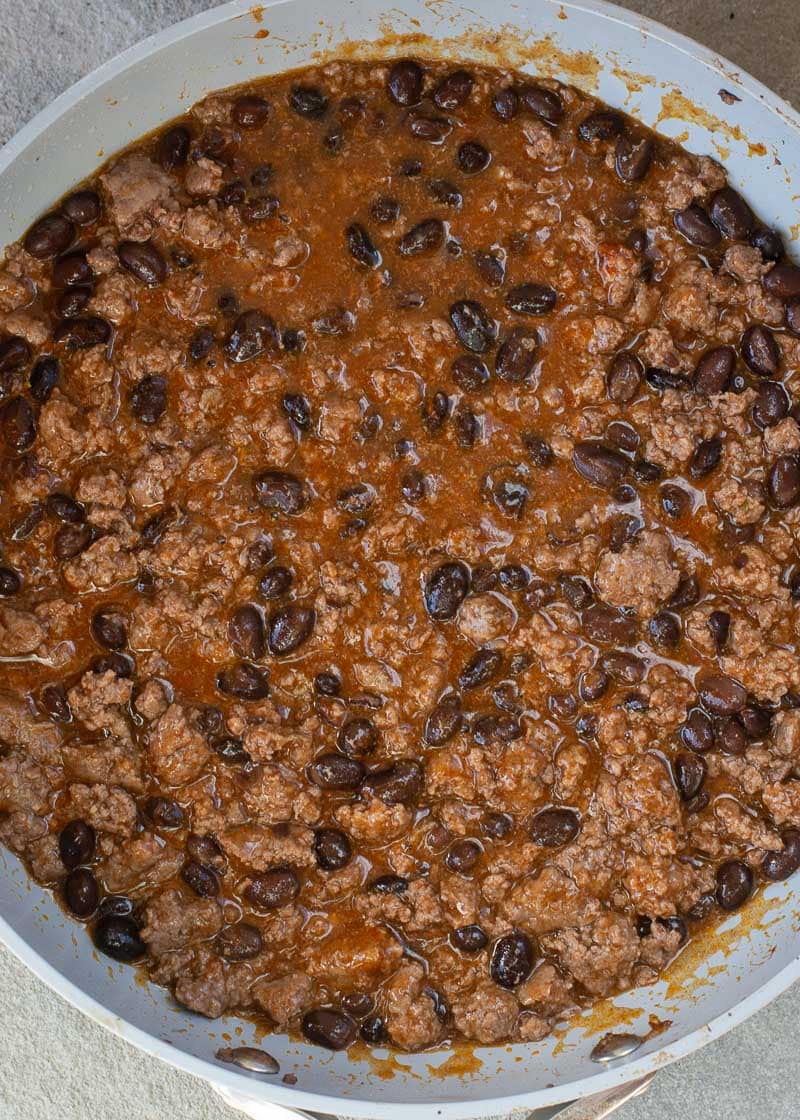 This super easy Skillet Enchiladas recipe will become a family favorite! Ground beef, black beans, a flavorful enchilada sauce, tortillas and cheese come together for a one-pan, 20-minute meal! 