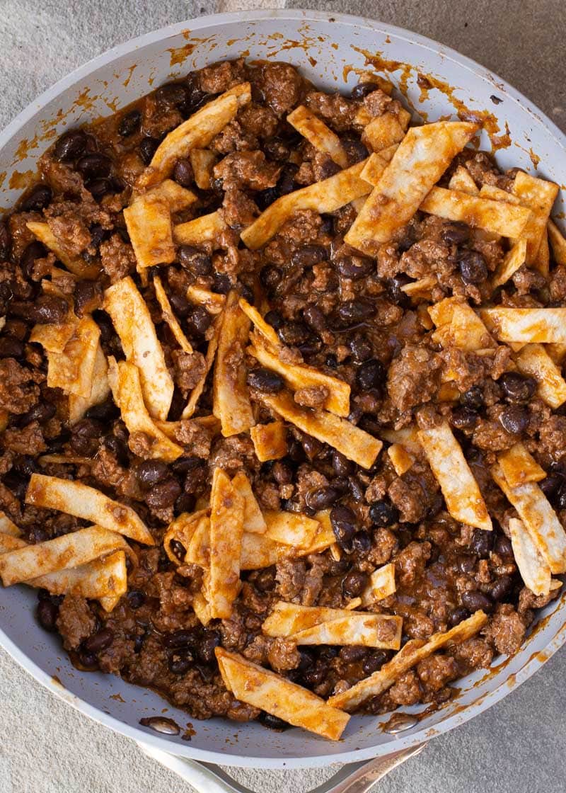 This super easy Skillet Enchiladas recipe will become a family favorite! Ground beef, black beans, a flavorful enchilada sauce, tortillas and cheese come together for a one-pan, 20-minute meal! 