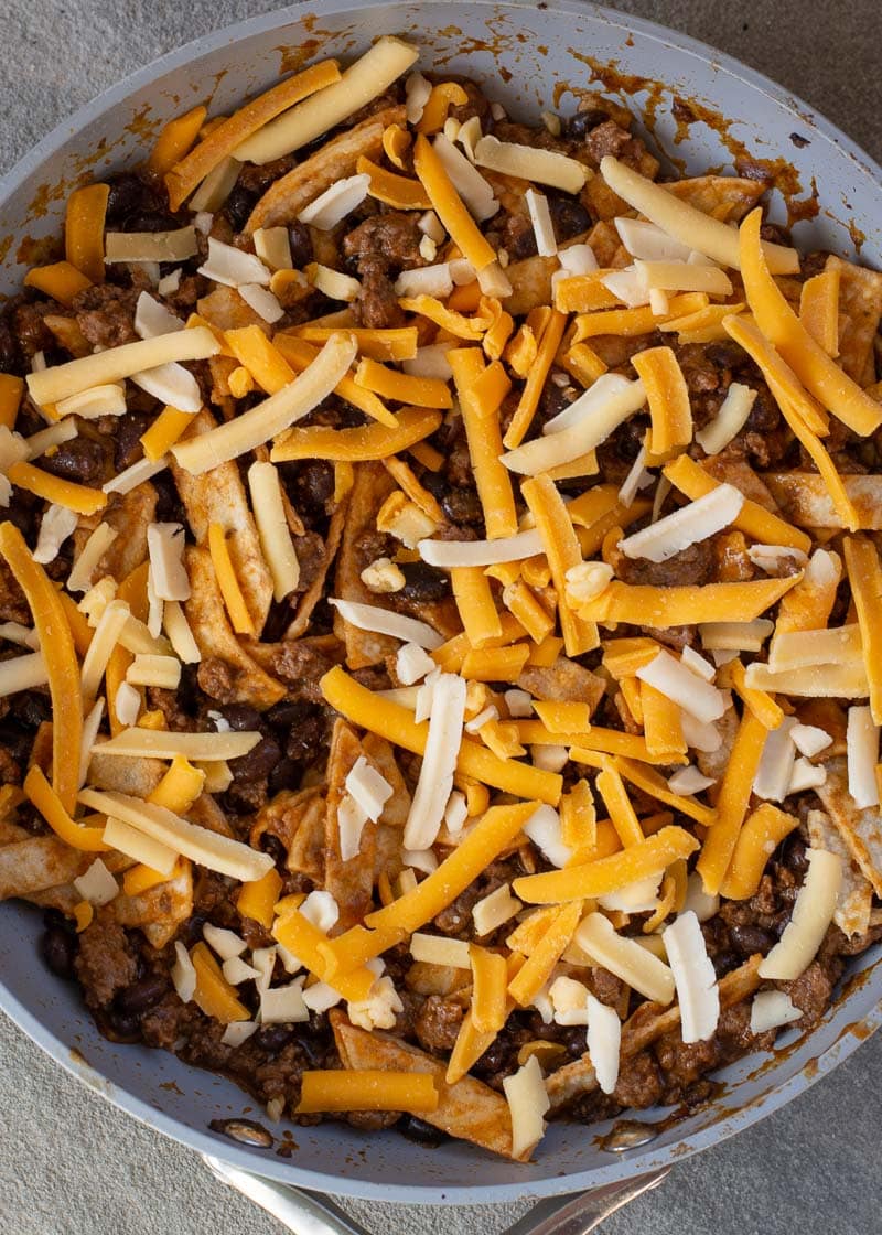 This super easy Skillet Enchiladas recipe will become a family favorite! Ground beef, black beans, a flavorful enchilada sauce, tortillas and cheese come together for a one-pan, 20-minute meal! 